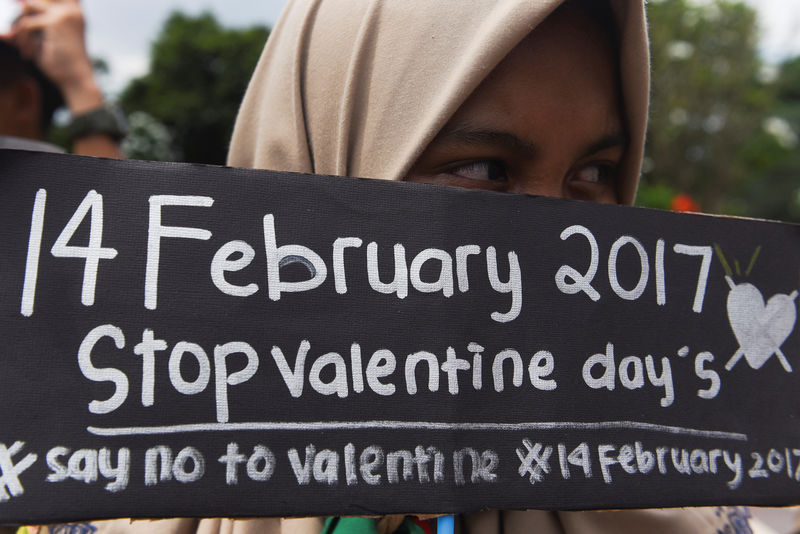 © Reuters. Estudante muçulmana segura cartaz em protesto contra o Dia dos Namorados em Surabaya, Indonésia