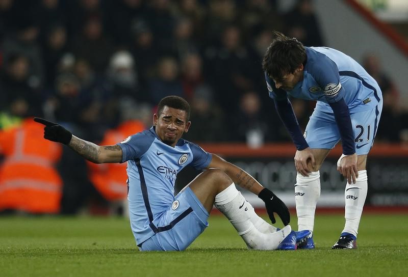 © Reuters. Manchester City's Gabriel Jesus sits after sustaining an injury as David Silva looks on