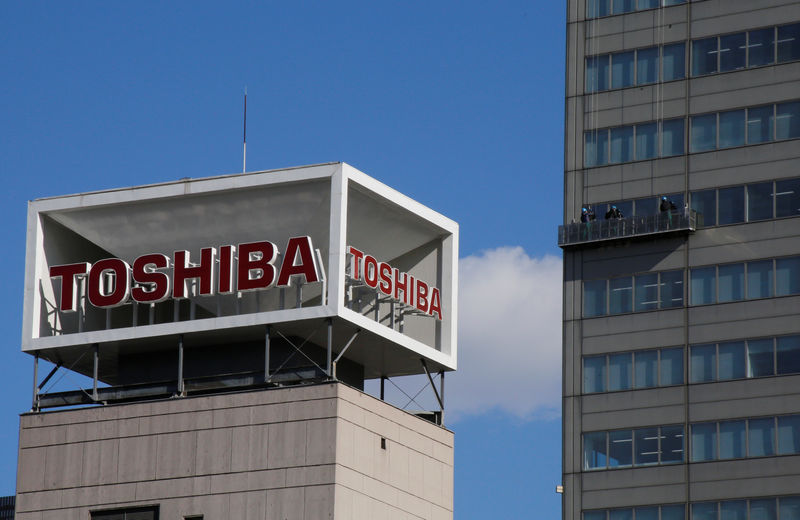 © Reuters. The logo of Toshiba Corp is seen as Window cleaners work on the company's headquarters in Tokyo