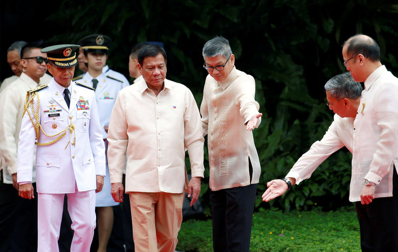 © Reuters. FILE PHOTO -  Incoming President Rodrigo Duterte walks towards outgoing President Benigno Aquino before Aquino leaves the Malacanang Palace in Manila