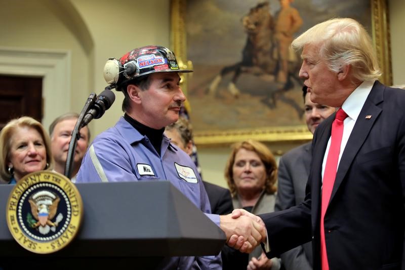 © Reuters. Michael Nelson, a coal miner worker shakes hands with U.S. President Donald Trump as he prepares to sign Resolution 38, at the White House in Washington, U.S.