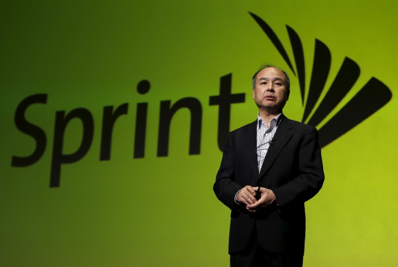 © Reuters. SoftBank Corp. Chief Executive Masayoshi Son speaks as the logo of their U.S. unit Sprint is backgroud in Tokyo