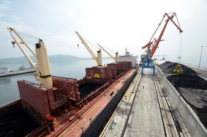 © Reuters. A cargo ship is loaded with coal during the opening ceremony of a new dock at the North Korean port of Rajin
