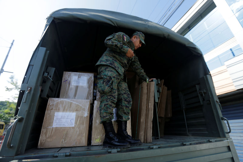 © Reuters. A soldier stands guard as transports ballot boxes and voting materials to polling stations ahead of Sunday's presidential election, in Guayaquil