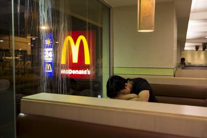 © Reuters. A man sleeps at a 24-hour McDonald's restaurant in Hong Kong, China