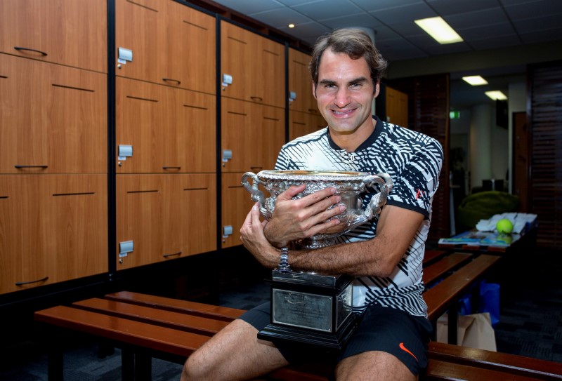 © Reuters. Switzerland's Roger Federer hugs the trophy after winning the Men's singles final at the Australian Open tennis tournament in Melbourne