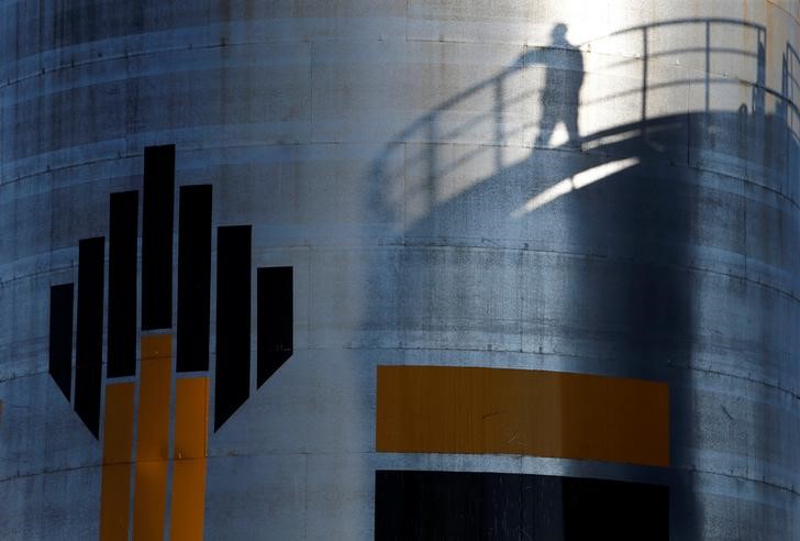 © Reuters. Тень рабочего на заводе Роснефти на Приобском месторождении под Нефтеюганском