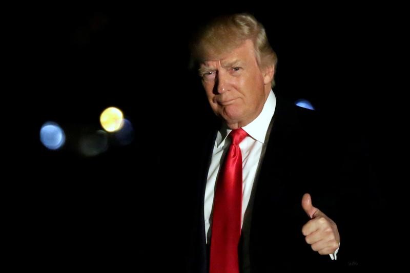 © Reuters. President Donald Trump gesture as he walks on the South Lawn