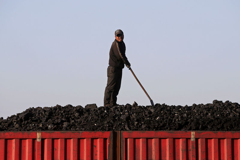 © Reuters. FILE PHOTO: A worker speaks as he loads coal on a truck at a depot near a coal mine from the state-owned Longmay Group on the outskirts of Jixi, Heilongjiang, China