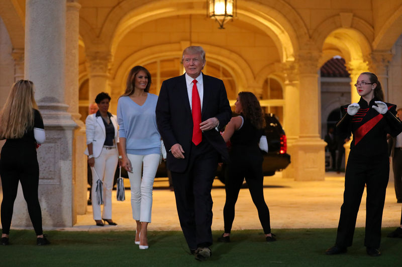 © Reuters. U.S. President Donald Trump and First Lady Melania Trump greet a marching band as they arrive at Trump International Golf club to watch the Super Bowl LI between New England Patriots and Atlanta Falcons in West Palm Beach, Florida, U.S.