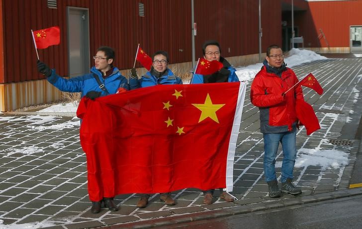 © Reuters. Pessoas exibem bandeiras nacionais chinesas ao lado de uma estrada por onde passava o presidente chinês, Xi Jinping, durante sua visita à Suíça na cidade de Wallisellen