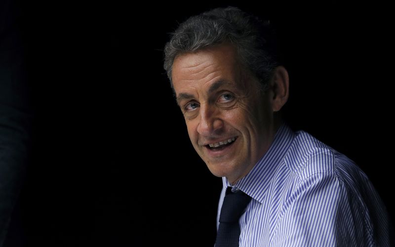 © Reuters. FILE PHOTO - Former French President Nicolas Sarkozy reacts during a visit in Poissy