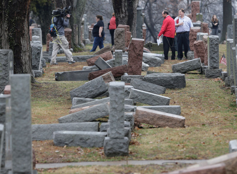 © Reuters. People view toppled Jewish headstones after a weekend vandalism attack on Chesed Shel Emeth Cemetery in University City