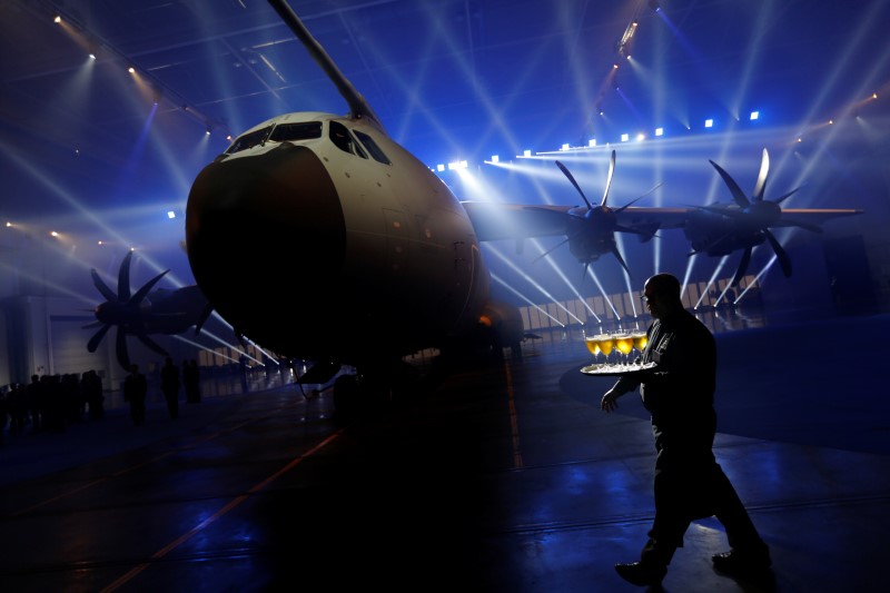 © Reuters. A waiter walks past an Airbus A400M military transport plane is parked at the Airbus assembly plant during an event in Seville, southern Spain