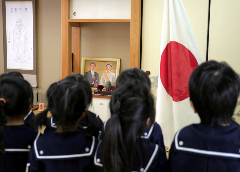 © Reuters. FILE PHOTO -  Students recite the Imperial Rescript on Education and Confucian Analects in front of JapanÕs national flag at Tsukamoto kindergarten in Osaka