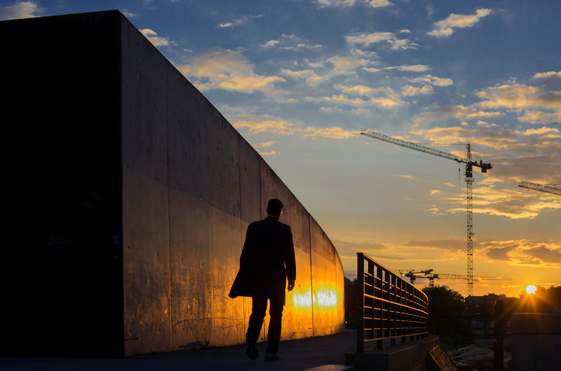 © Reuters. FILE PHOTO: A man walks along the embankment of the river Spree during sunset in Berlin.