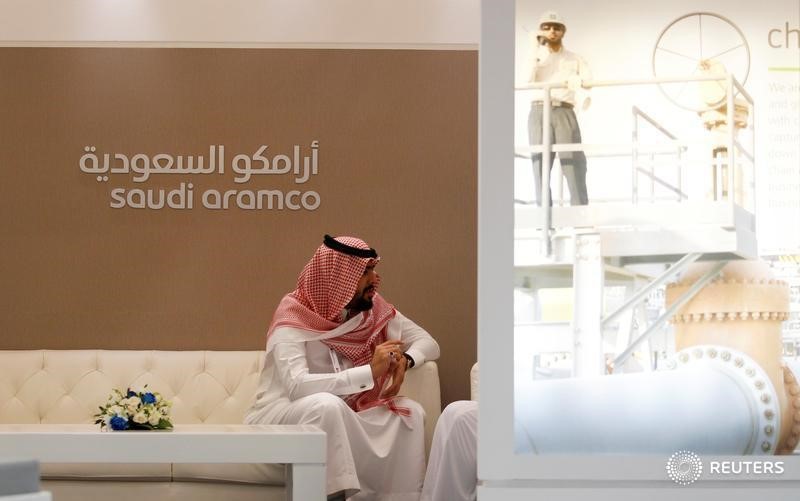 © Reuters. Сотрудник Saudi Aramcoсидит рядом со стендом компании на выставке Middle East Petrotech 2016