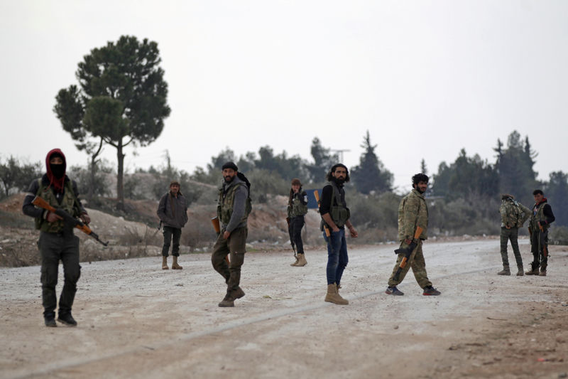 © Reuters. FILE PHOTO -  A file photo shows free Syrian Army fighters carrying their weapons as they stand on the outskirts of the northern Syrian town of al-Bab