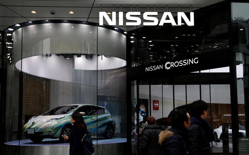 © Reuters. People walk past a Nissan Motor Co's showroom in Tokyo