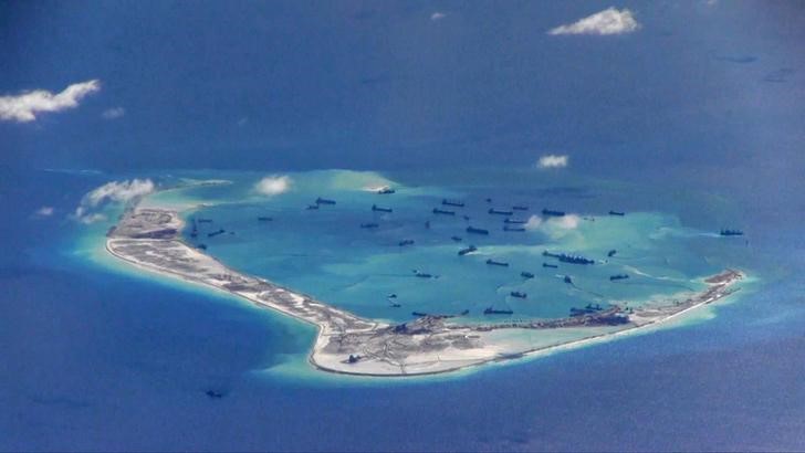 © Reuters. Кадр из видеозаписи ВМС США, на котором запечатлены предположительно китайские дноуглубительные суда у рифа Мисчиф