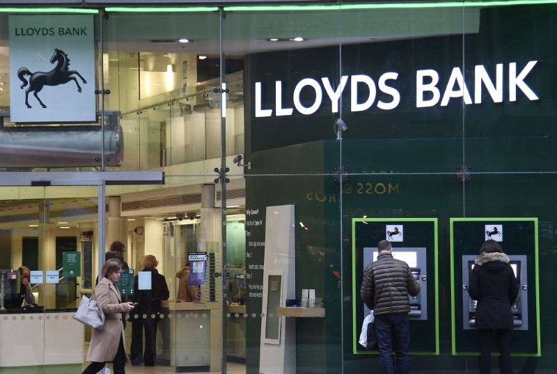 © Reuters. Customers use ATMs at a branch of Lloyds Bank in London