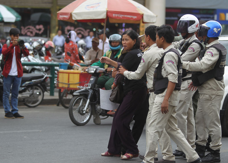 © Reuters. Protesters are pushed back by district authorities as they demonstrate in support of land rights activist Tep Vanny during her verdict in front of the Phnom Penh Municipal Court in central Phnom Penh