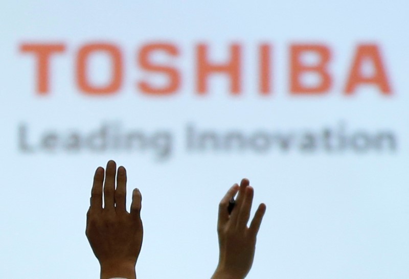 © Reuters. Reporters raise their hands for a question during a news conference by Toshiba Corp CEO Satoshi Tsunakawa and other senior sompany officials at the company's headquarters in Tokyo, Japan