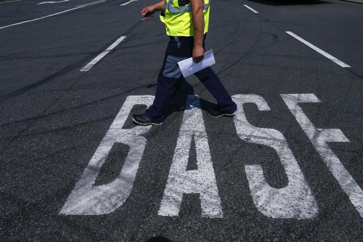 © Reuters. A truck driver walks along a BASF sign on the road near the warehouse of German chemical company BASF in Ludwigshafen
