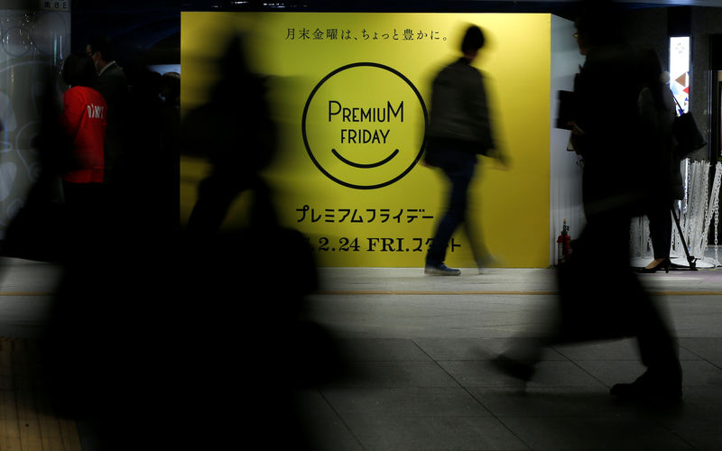 © Reuters. People walk past the logo of Premium Friday campaign in Tokyo
