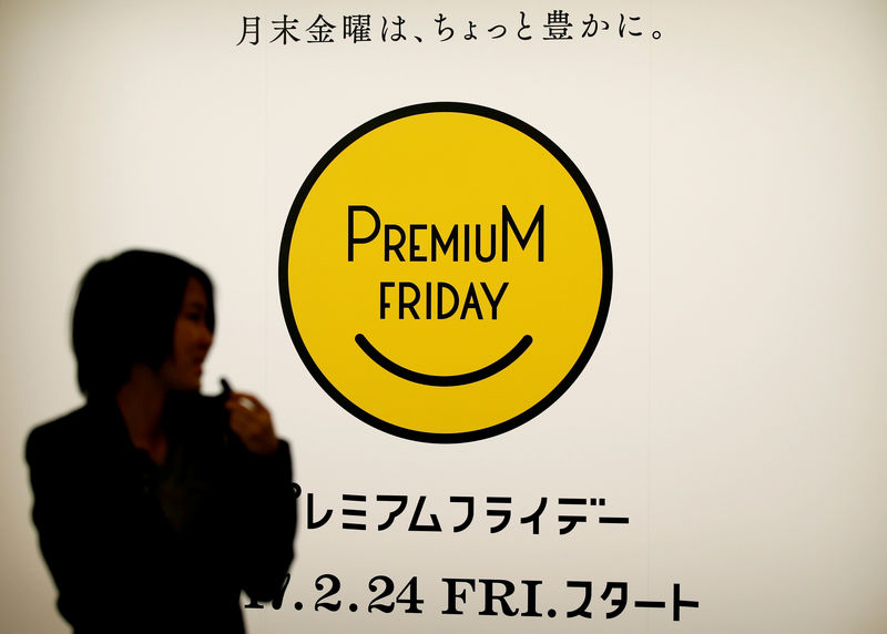 © Reuters. Woman walks past the logo of Premium Friday campaign in Tokyo
