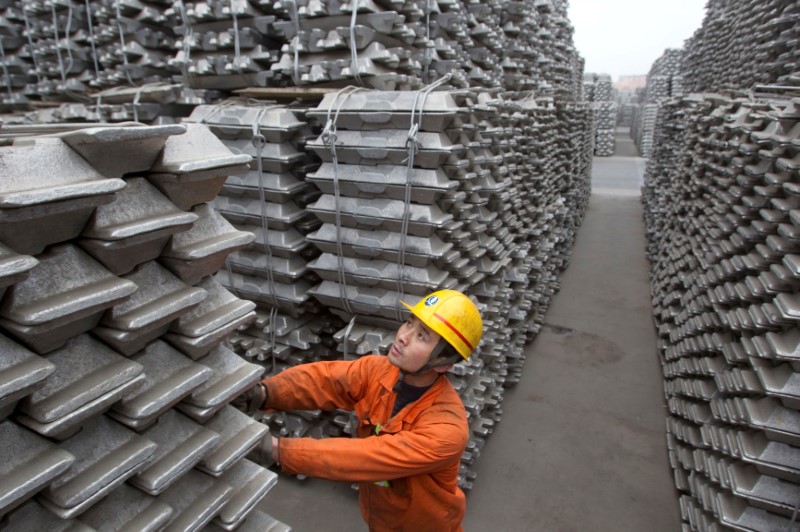 © Reuters. An employee checks aluminium ingots for export at the Qingdao Port