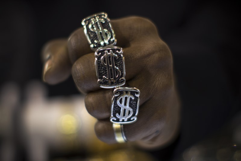 © Reuters. A man wears dollar sign rings in a jewellery shop in Manhattan in New York City