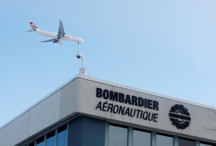© Reuters. FILE PHOTO -  A plane flies over a Bombardier plant in Montreal