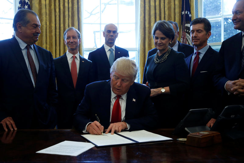 © Reuters. Trump is surrounded by business leaders as he signs an executive order on regulatory reform at the White House