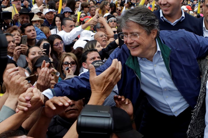 © Reuters. Supporters of Guillermo Lasso, presidential candidate from the CREO party and other opposition supporters stand outside the electoral council (CNE) headquarters, in Quito