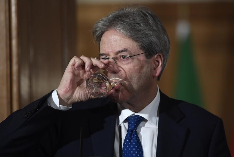 © Reuters. Italy's Prime Minister Paolo Gentiloni pauses for a drink during a press conference with his counterpart from Britain Theresa May (not shown) at Number 10 Downing Street in London