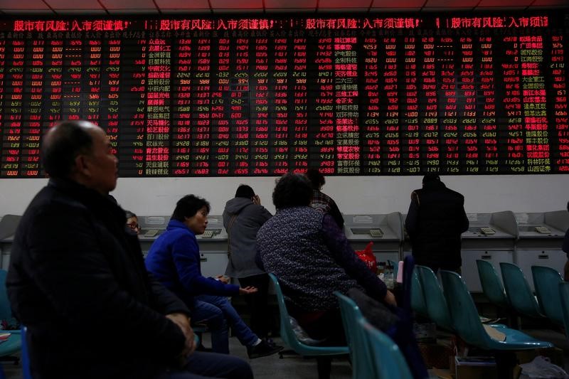 © Reuters. Investors look at an electronic board showing stock information on the first trading day after the New Year holiday at a brokerage house in Shanghai