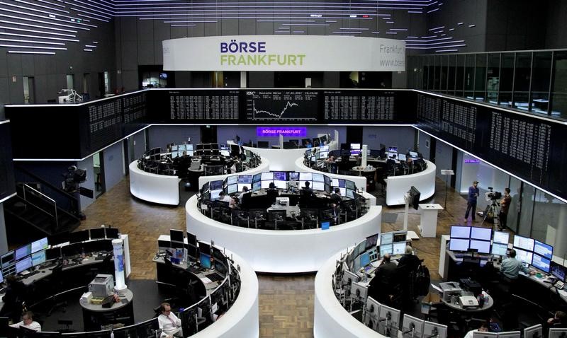 © Reuters. Traders work at their desks in front of the German share price index DAX board in Frankfurt