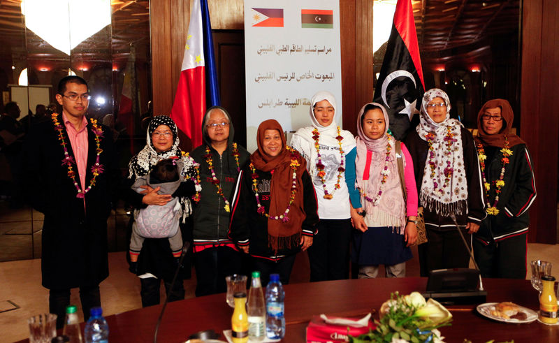 © Reuters. Filipino nurses, who were freed from Islamic State militants by Libyan forces in Sirte, pose for a group photo during a handover ceremony in the presence of a Filipino envoy in Tripoli