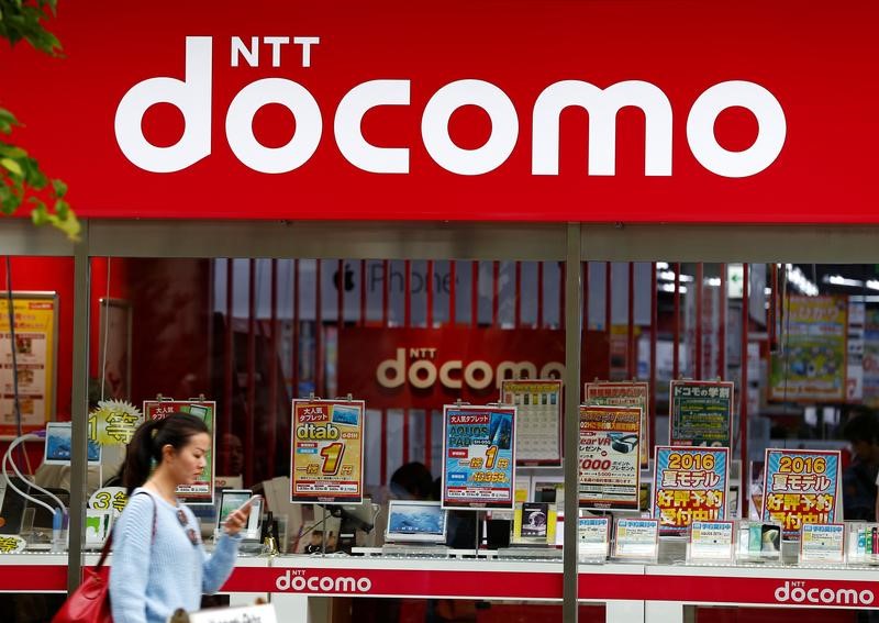 © Reuters. A woman walks past a brach of Japanese mobile communications company NTT Docomo in Tokyo