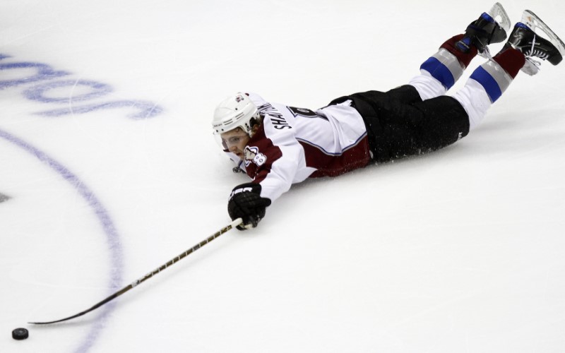 © Reuters. Colorado Avalanche's Shattenkirk fall to the ice as he tries to control the puck against Phoenix Coyotes during the second period of their NHL hockey game in Glendale