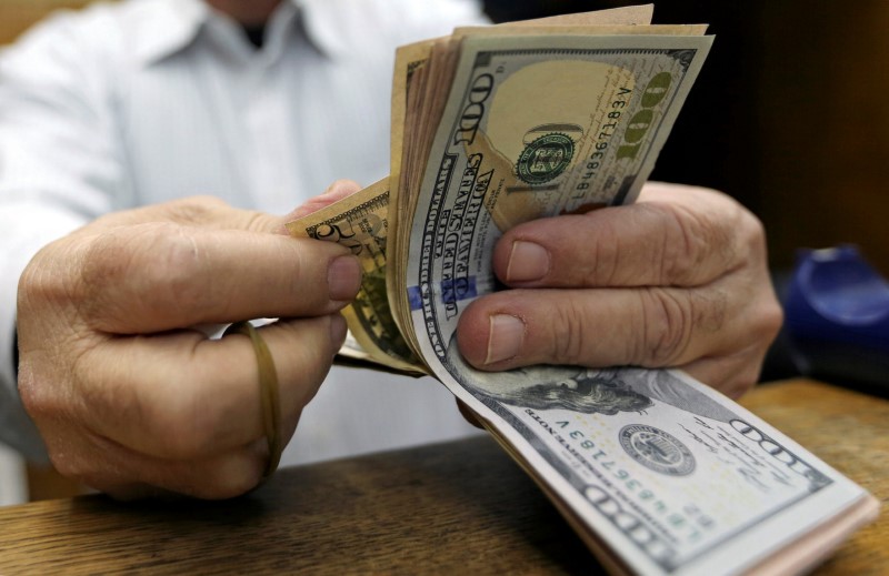 © Reuters. A man counts U.S dollars at a money exchange office in central Cairo