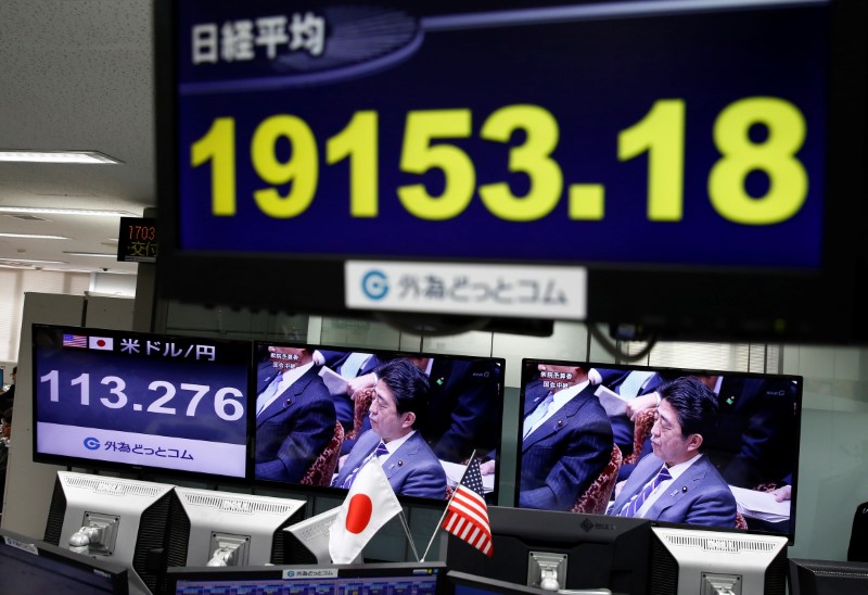 © Reuters. A TV monitor showing Japanese Prime Minister Shinzo Abe is seen next to monitors showing the Japanese yen's exchange rate against the U.S. dollar and Nikkei average at a foreign exchange trading company in Tokyo