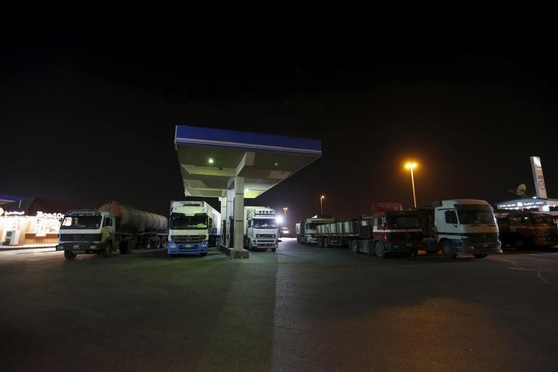 © Reuters. Trucks wait for fuel pumps to reopen after morning prayers, during early hours at a petrol station in Khobar, west of Riyadh