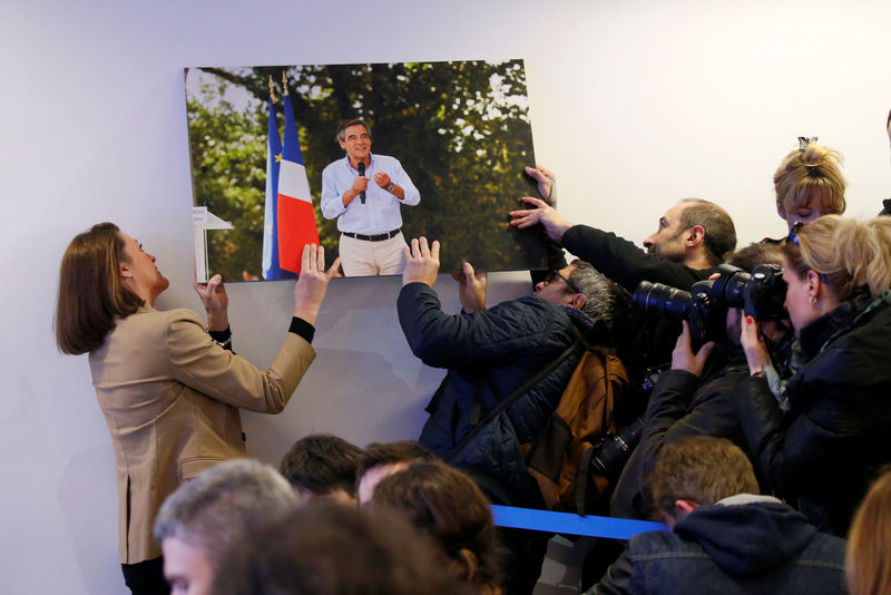 © Reuters. Journalists try to hang a picture of Francois Fillon which fell before a news conference in Paris, France