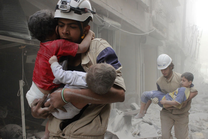 © Reuters. Members of the Civil Defence rescue children after what activists said was an air strike by forces loyal to Syria's President Assad in al-Shaar neighbourhood of Aleppo