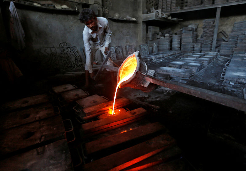 © Reuters. A worker pours molten iron from a ladle to make lamp posts inside an iron casting factory in Ahmedabad