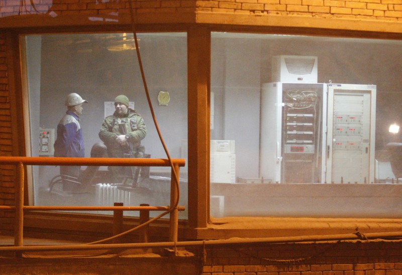 © Reuters. An armed man speaks with an employee at Yuzovsky metallurgical plant in Donetsk