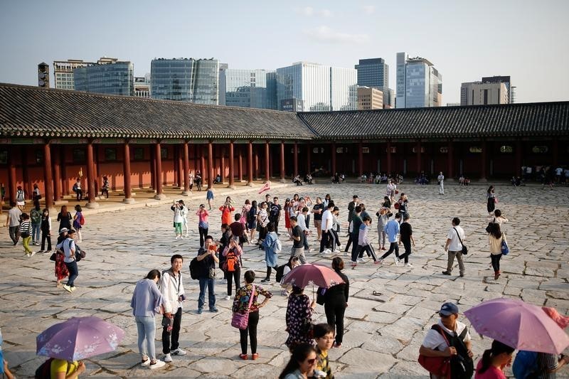 © Reuters. Chinese tourists walk in the Gyeongbok Palace in central Seoul