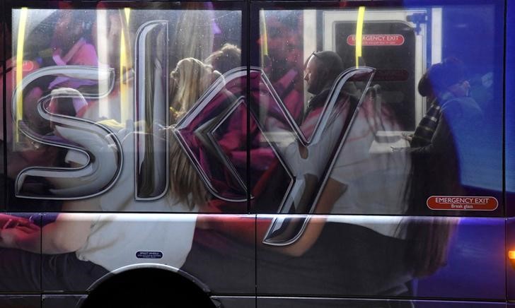 © Reuters. FILE PHOTO: Workers ride on a Sky employee shuttle bus near their headquarters in west London